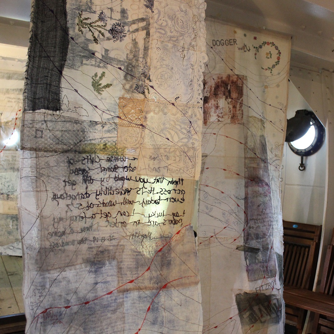 Hanging textile art piece linen with embroidered writing and nature motifs