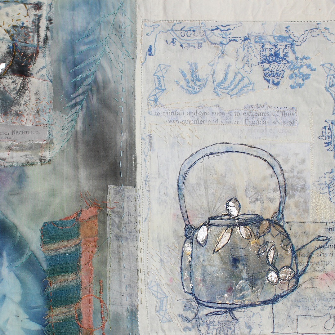 Close up of a textile art piece featuring printed flowers and an embroidered kettle