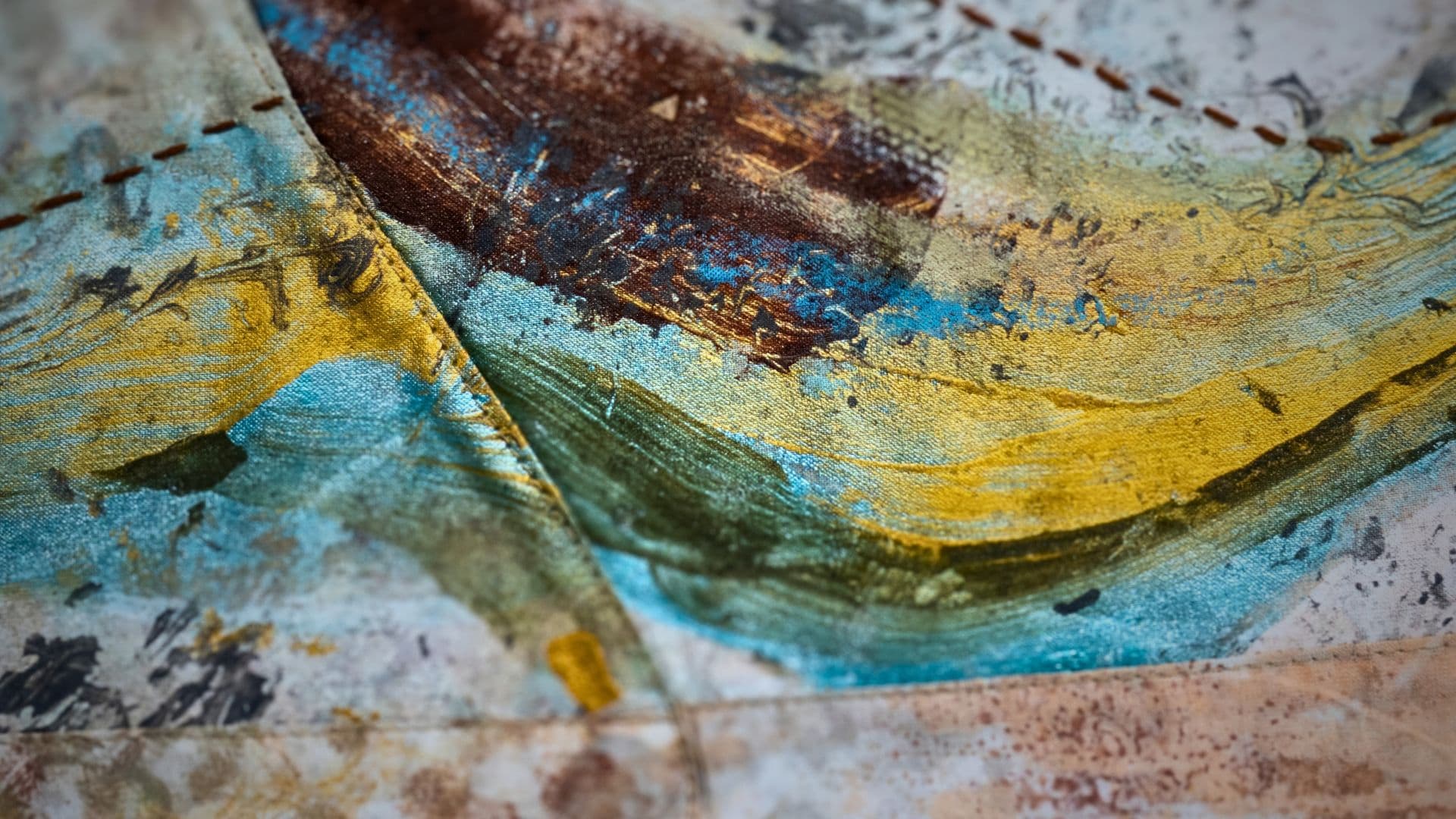 A close up of Monoprinting, direct painting, machine pieced & hand stitch.